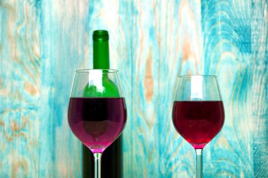 Ahşap arka planda şarap kadehi ve şişe.