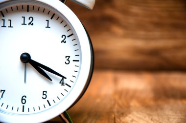 Beyaz çalar saat üzerinde ahşap arka plan izole