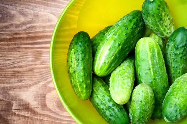 Mini pepinos en tazón en la mesa —  Fotos de Stock