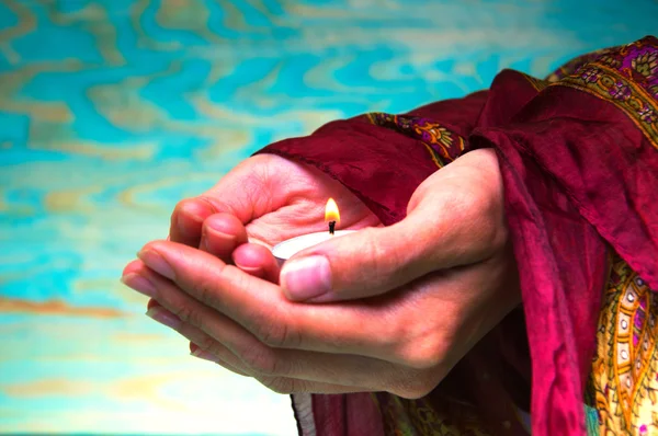 Bir çay ışık mum holding oryantal kadının eller