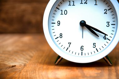 Beyaz çalar saat üzerinde ahşap arka plan izole