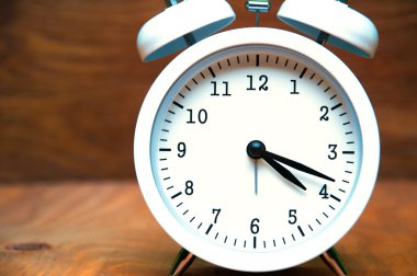 Beyaz çalar saat üzerinde ahşap arka plan izole