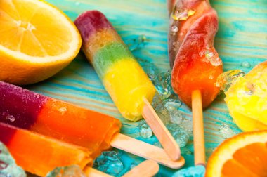 Renkli Buz lolly ve mavi ahşap zemin üzerine friuts