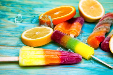 Renkli Buz lolly ve mavi ahşap zemin üzerine friuts