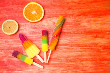 Kırmızı ahşap arka plan üzerinde renkli Buz lolly