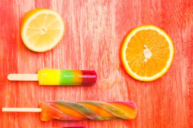 Kırmızı ahşap arka plan üzerinde renkli Buz lolly