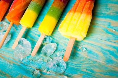 Mavi ahşap arka plan üzerinde renkli Buz lolly