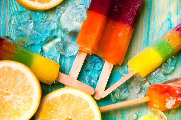 Kleurrijke ice lolly en friuts op blauwe houten achtergrond — Stockfoto