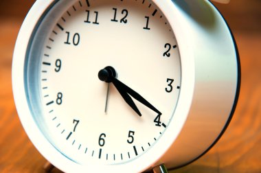 Beyaz çalar saat üzerinde ahşap arka plan izole