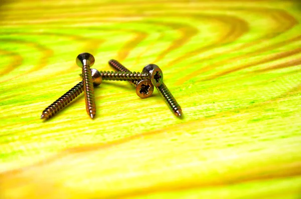 Tornillos sobre mesa de madera verde —  Fotos de Stock