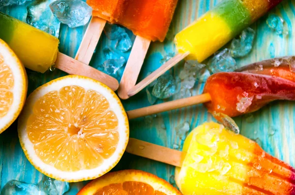 Sorvete, frutas suculentas e cubos de gelo em fundo de madeira — Fotografia de Stock