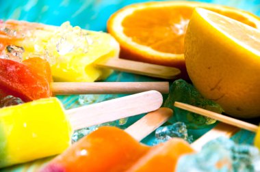 Renkli Buz lolly ve mavi ahşap zemin üzerine friuts