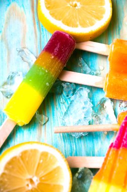 Renkli Buz lolly ve mavi ahşap zemin üzerine friuts