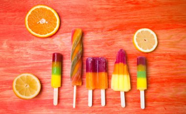 Kırmızı ahşap arka plan üzerinde renkli Buz lolly