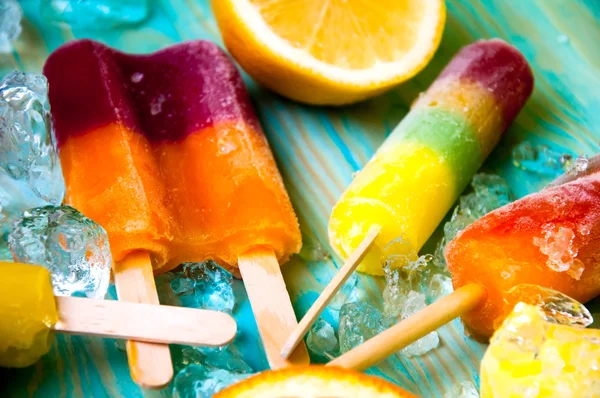 Renkli Buz lolly ve mavi ahşap zemin üzerine friuts