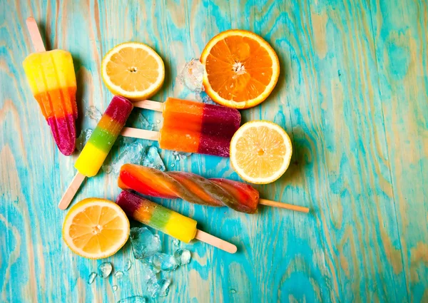 Kleurrijke ice lolly en friuts op blauwe houten achtergrond — Stockfoto