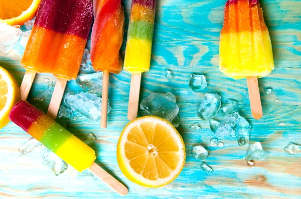 Renkli Buz lolly ve mavi ahşap zemin üzerine friuts