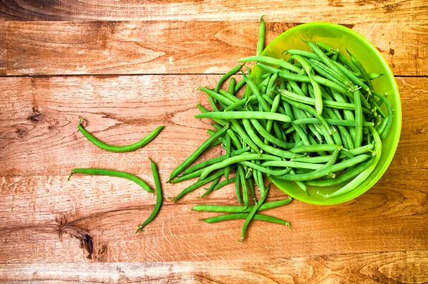 Fresh green beans in bowl on wooden table — Stock Photo, Image