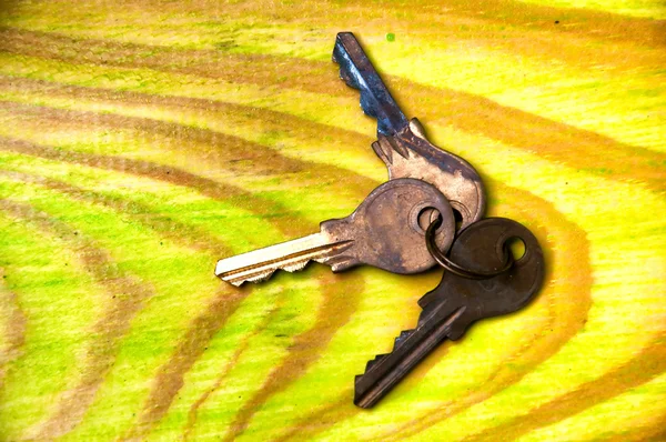 Old rusty keys on green wooden table — Stock Photo, Image