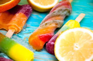 Renkli Buz lolly ve mavi ahşap zemin üzerine friuts