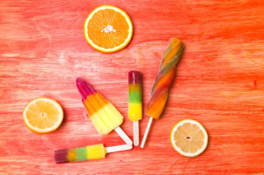 Kırmızı ahşap arka plan üzerinde renkli Buz lolly