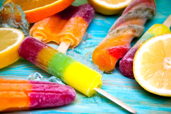 Kleurrijke ice lolly en friuts op blauwe houten achtergrond — Stockfoto