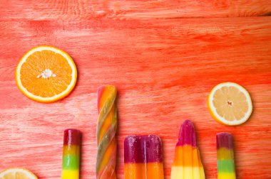 Kırmızı ahşap arka plan üzerinde renkli Buz lolly
