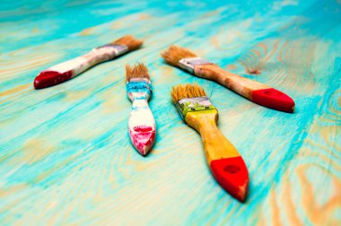 Mavi ahşap masa üzerinde yağlı boya fırçaları