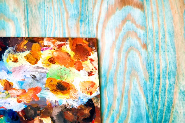 Malpalette auf farbigem Holzgrund — Stockfoto