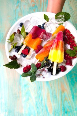 Lezzetli dondurma ve meyve buz küpleri ile hizmet veren eller