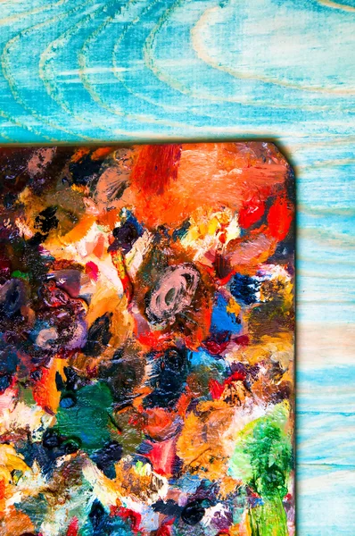 Paleta de pintura sobre fundo de madeira colorido — Fotografia de Stock