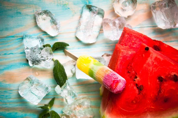 Karpuz ve mavi ahşap arka plan dondurmanın parçalar