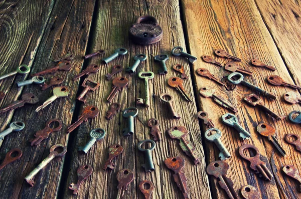 Old rusty padlock and keys on wooden background — Stock Photo, Image