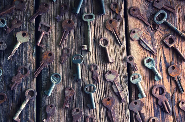 Eski paslı asma kilit ve anahtarları ahşap arka plan üzerinde