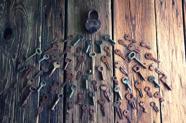 Old rusty padlock and keys on wooden background — Stock Photo, Image