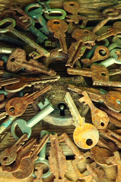 Old rusty padlock and keys on wooden background — Stock Photo, Image