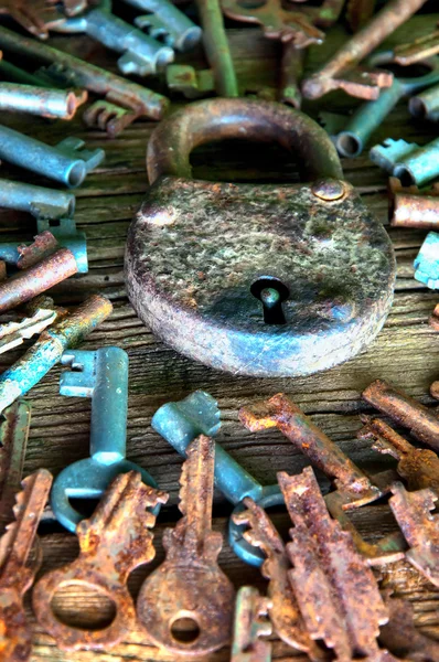 Old rusty padlock and keys on wooden background — Stock Photo, Image