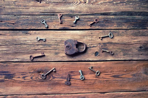 Starý rezavý zámek a klíče na dřevěné pozadí — Stock fotografie