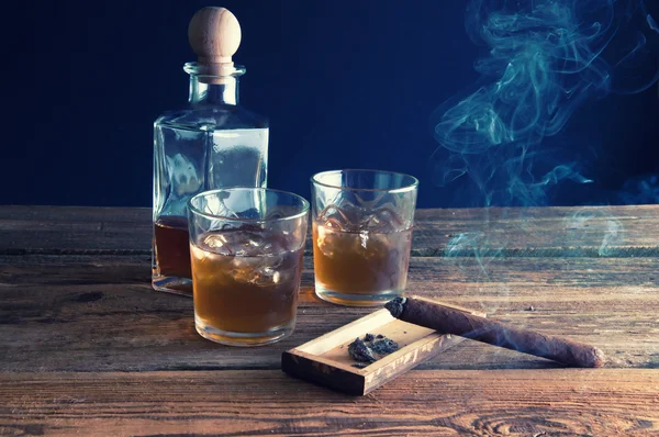 Whisky s ledem a doutník na dřevěný stůl — Stock fotografie