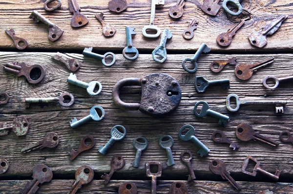 Old rusty padlock and keys on wooden background — Stock Photo, Image