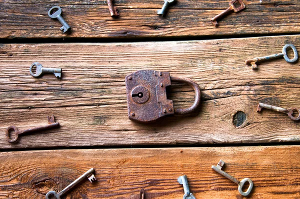 Régi rozsdás lakat és a kulcsokat a fából készült háttér — Stock Fotó