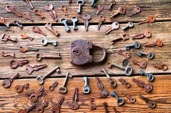 Old rusty padlock and keys on wooden background — Stock Photo, Image