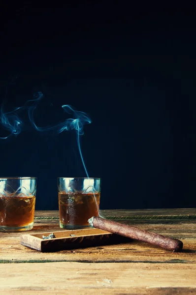 Cigar and whisky with ice on wooden table — Stock Photo, Image