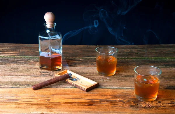 Cigar and whisky with ice on wooden table — Stock Photo, Image