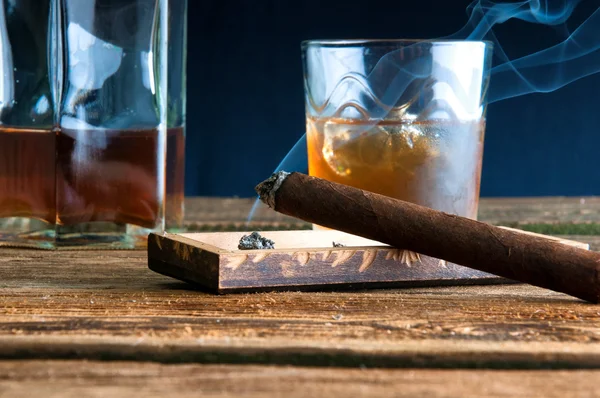 Cigar and whisky with ice on wooden table — Stock Photo, Image