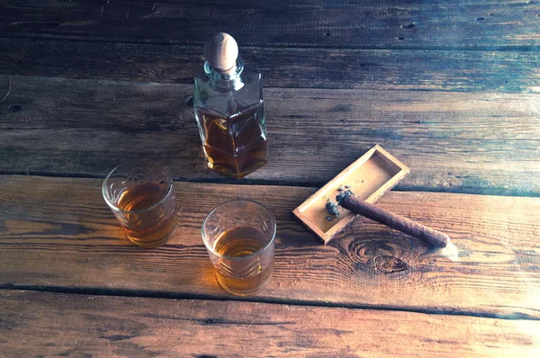 Cigarros y whisky con hielo sobre mesa de madera —  Fotos de Stock