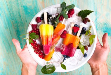 Lezzetli dondurma ve meyve buz küpleri ile hizmet veren eller