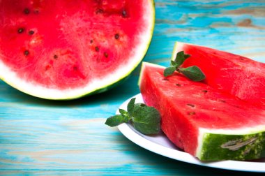 Karpuz mavi ahşap arka plan üzerinde parçaları