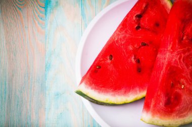 Karpuz mavi ahşap arka plan üzerinde parçaları