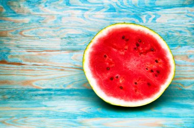 Karpuz mavi ahşap arka plan üzerinde yarısı